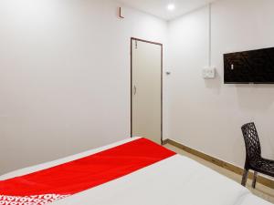 1 dormitorio con 1 cama con manta roja en Super OYO Flagship Kompally Residency, en Hyderabad
