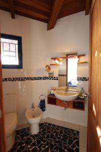 bagno con lavandino, servizi igienici e specchio di L' Ancora - Room With Exclusive Pool And Terrace a Palmeira