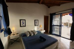 een slaapkamer met een bed en een grote glazen schuifdeur bij L' Ancora - Room With Exclusive Pool And Terrace in Palmeira