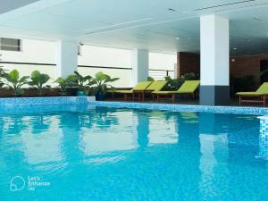 a large swimming pool in a building with chairs at Daisy Flower Nha Trang in Nha Trang