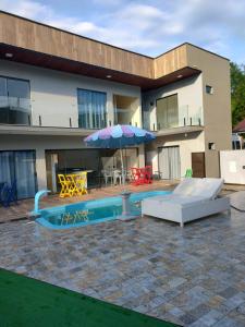 a house with a swimming pool with an umbrella at Morada Stucchi in Balneário Camboriú