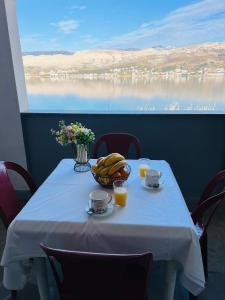 a table with a bowl of food and drinks on it at Apartments Mia Pag in Pag