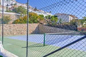 una cancha de tenis con una red en una cancha de tenis en Villa Infinite, en Salobreña