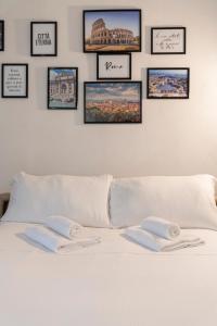 a white bed with four pictures on the wall at Studio Flat - Lungara 44A in Rome