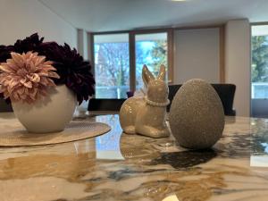 un tavolo con due conigli e un vaso con fiori di Grand Apartment Sissi a Trieste