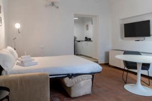 a bedroom with a bed and a table and a tv at Studio Flat - Lungara 44A in Rome