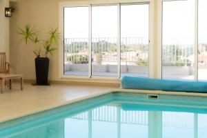 einen Pool in einem Zimmer mit Fenstern in der Unterkunft Hôtel Mar I Cel & Spa in Canet-en-Roussillon