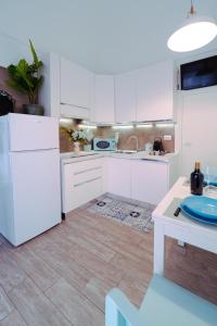 uma cozinha com armários brancos e um frigorífico branco em Casa Celeste em Monopoli