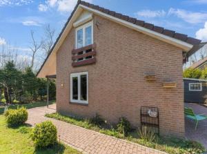 a brick house with a window and a patio at Vakantiehuis vlakbij Duitse grens in Beek