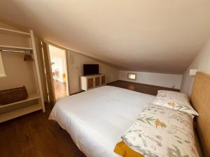 a bedroom with a large white bed in a attic at La Mansarda degli Ulivi in Portoferraio
