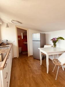 a kitchen with a white table and a white refrigerator at La Mansarda degli Ulivi in Portoferraio