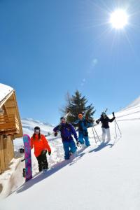 a group of people walking down a snow covered slope at Chalet Aravis in Le Grand-Bornand