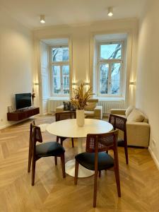 a living room with a table and chairs and a couch at Maison Frank in Budapest