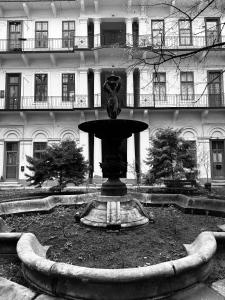 a fountain in a courtyard in front of a building at Maison Frank in Budapest
