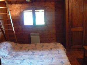 a bedroom with a bed and a window at Chalet Aravis in Le Grand-Bornand