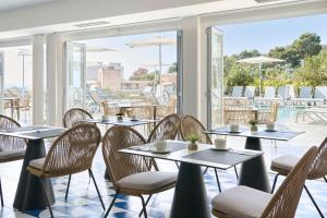 a restaurant with tables and chairs and a pool at Exe Portals Nous in Portals Nous