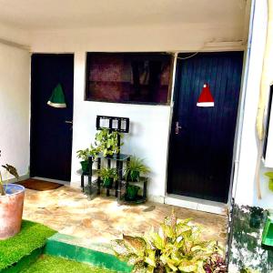 zwei Türen eines Hauses mit Topfpflanzen darauf in der Unterkunft Cozy Studio Apartment in Daressalam