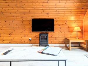 sala de estar con pared de madera y TV en Balor 1 - Hot Tub-Perth-Pets, en Perth