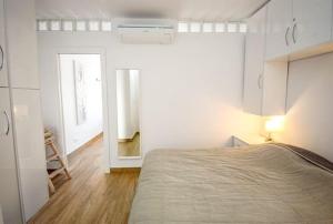 a white bedroom with a bed and a mirror at CASITA BONITA NERJA in Nerja