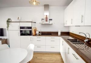a white kitchen with white cabinets and a sink at CASITA BONITA NERJA in Nerja