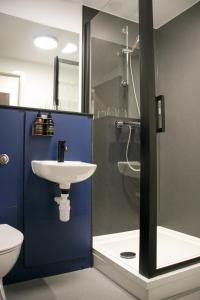 uma casa de banho com um WC, um lavatório e um chuveiro em The Base Camp Hotel, Nevis Range em Fort William
