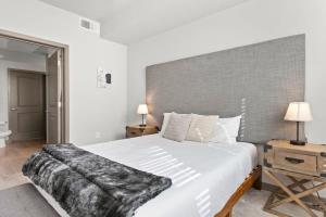 a bedroom with a large white bed with a large headboard at Cozysuites PHX RORO Gym Pool Pets Parking #12 in Phoenix +37 photos