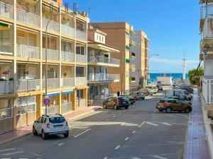 a street with cars parked in front of buildings at ¡El Pescador - junto al mar! in Santa Pola