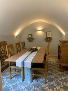 a dining room with a wooden table and chairs at Beautiful Georgian cottage within a private walled garden in Oakham