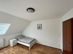 Habitación blanca con cama y ventana en Eterna Smart Living en Krefeld