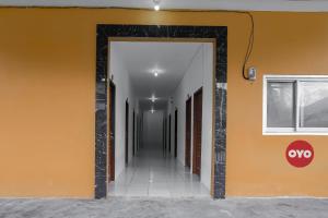 un couloir avec un mur orange et une porte ouverte dans l'établissement Super OYO 92626 Good Sleep 4 Inn Dcos Syariah, à Samarinda