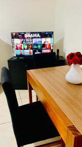 a wooden table with a vase on it with a television at Loano II - Confort Moderno en Primer Piso con acceso por escalera! in Belén de Escobar