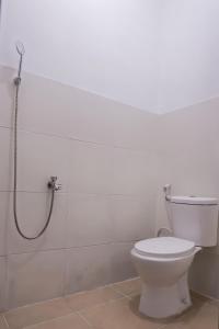 La salle de bains est pourvue d'une douche et de toilettes. dans l'établissement Super OYO 92626 Good Sleep 4 Inn Dcos Syariah, à Samarinda