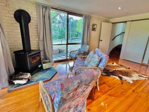Wonga Park的住宿－Perfect View Retreat in Forest，客厅设有壁炉、沙发和椅子