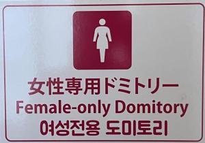 a red and white sign with a female only bathroom at Wasabi Mita Hotel in Tokyo