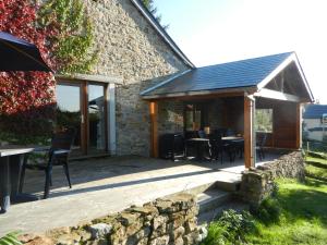 a stone cottage with a table and chairs on a patio at La Cense De Renière in Ferrières