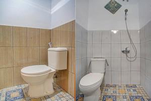 een badkamer met een toilet en een douche bij OYO 3994 Wisma Amalia in Bandar Lampung
