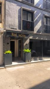 a hotel with two potted plants in front of a building at ROİ HOTEL İZMiR in İzmir