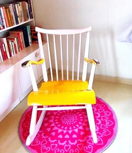 ein gelber Stuhl auf einem rosa Teppich in der Unterkunft Villa Mummola Kahden makuuhuoneen huoneisto lähellä jokea in Simpele