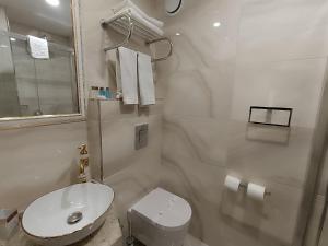 a white bathroom with a toilet and a sink at Golden Horn Hotel in Istanbul