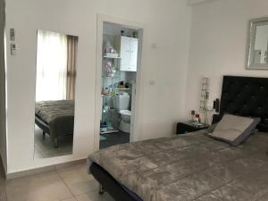 a bedroom with a bed and a mirror at Panorama superieur in Netanya