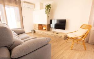 a living room with a couch and a television at El sueño del Búho 3. Chimenea y terraza. in Beceite