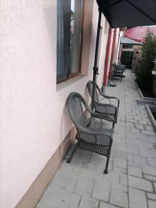 rzędu ławek siedzących na boku budynku w obiekcie Casa Millelune w mieście Fokszany