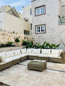 a couch sitting on a patio in front of a building at Seafront Beach House in St.Julians in Sliema
