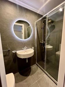 a bathroom with a sink and a shower with a mirror at Seafront Beach House in St.Julians in Sliema