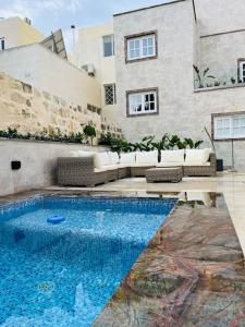 a swimming pool in front of a building at Seafront Beach House in St.Julians in Sliema