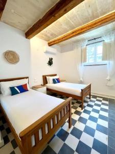 a bedroom with two beds and a checkered floor at Seafront Beach House in St.Julians in Sliema