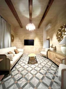 a living room with a couch and a tv at Seafront Beach House in St.Julians in Sliema