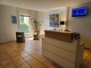 a lobby with a reception desk and a tile floor at Best Western H&ocirc;tel Le Sud in Manosque