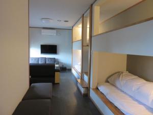 a bedroom with a bunk bed and a television at 御宿しんしま in Matsuzaki