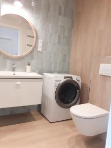 a bathroom with a washing machine and a toilet at Polanki Aqua Nature View in Kołobrzeg